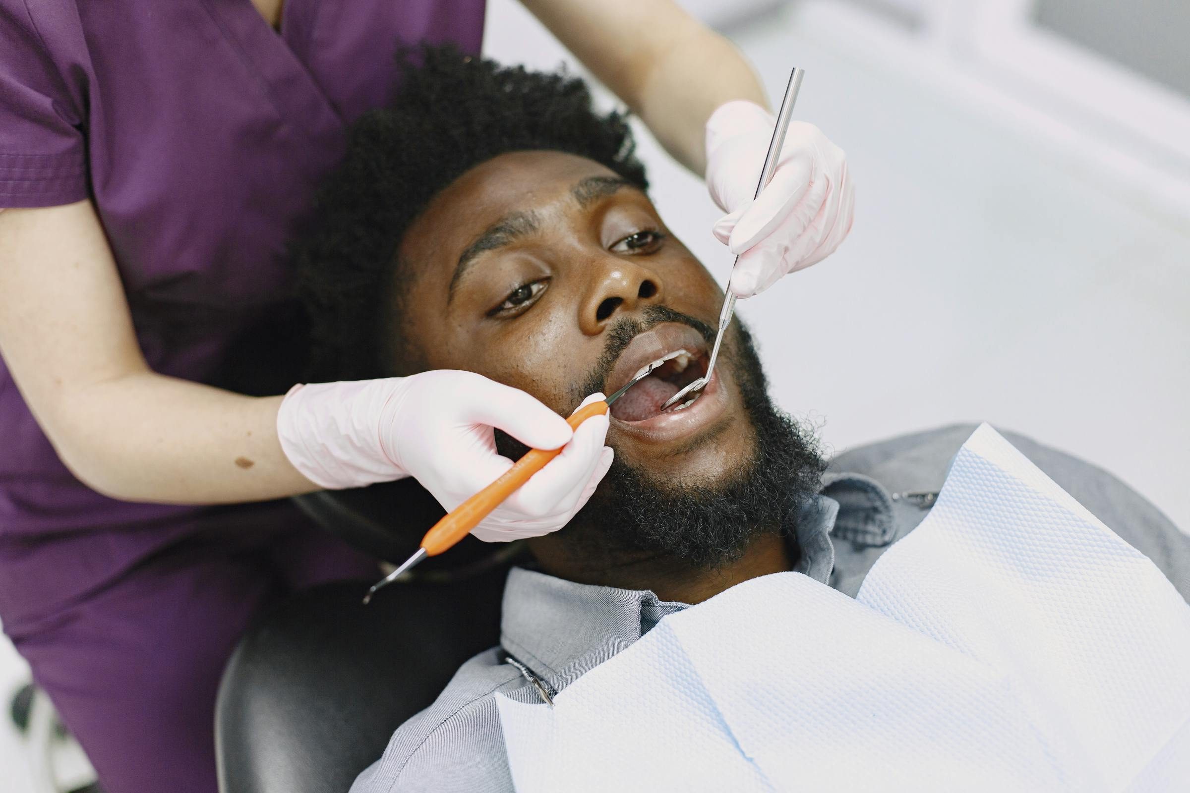 An adult man being examined by a dentist during a routine six-monthly check-up