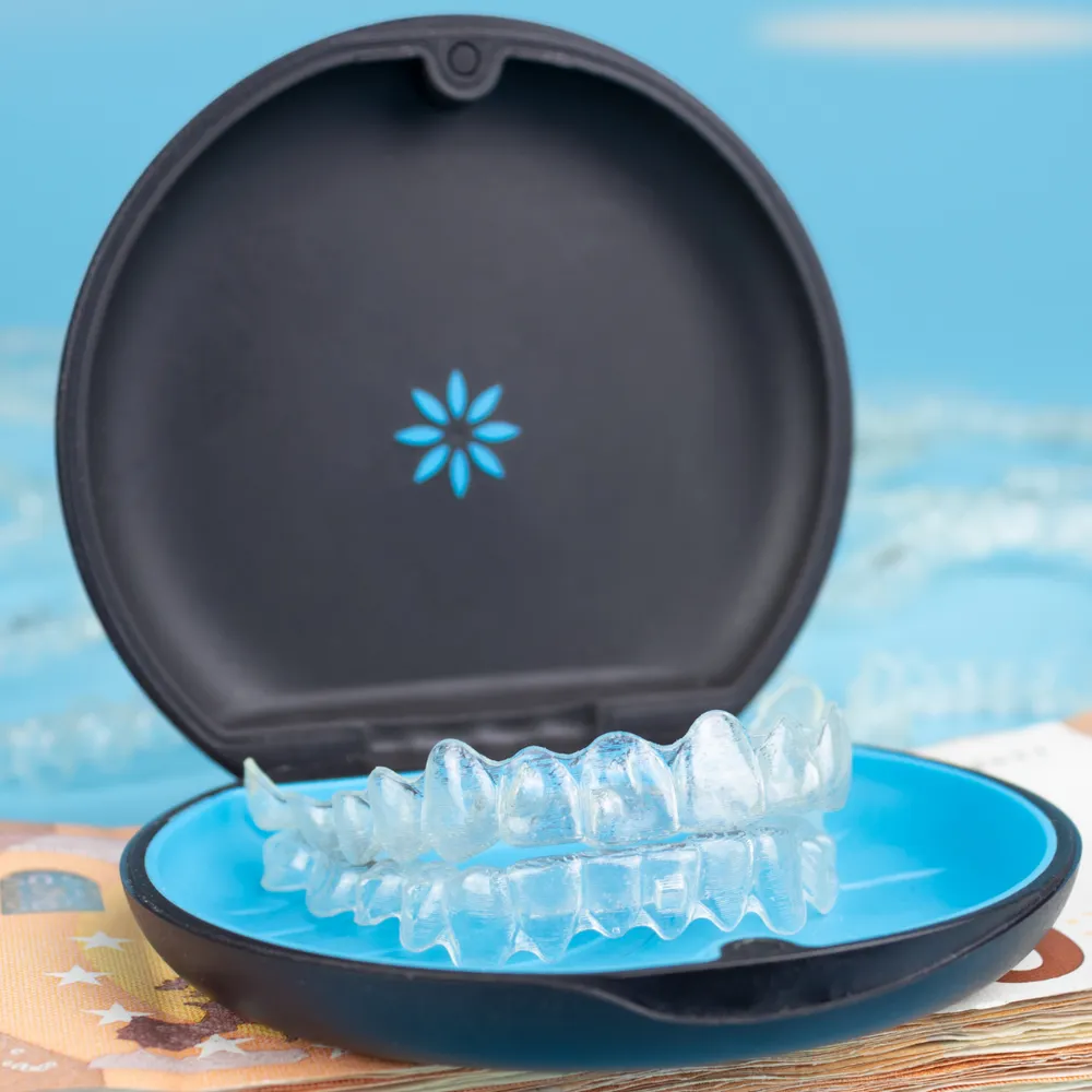 A clear Invisalign aligner tray resting inside its blue and black storage case — the case Campos Dental patients are given to keep their aligners safe when not wearing them.
